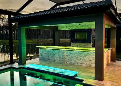 Swim-Up glass bar top in outdoor kitchen with LEDs by Downing Designs